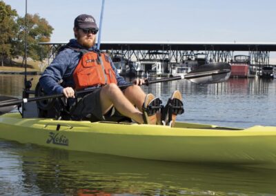 person using a single boat with padle and fishing rod